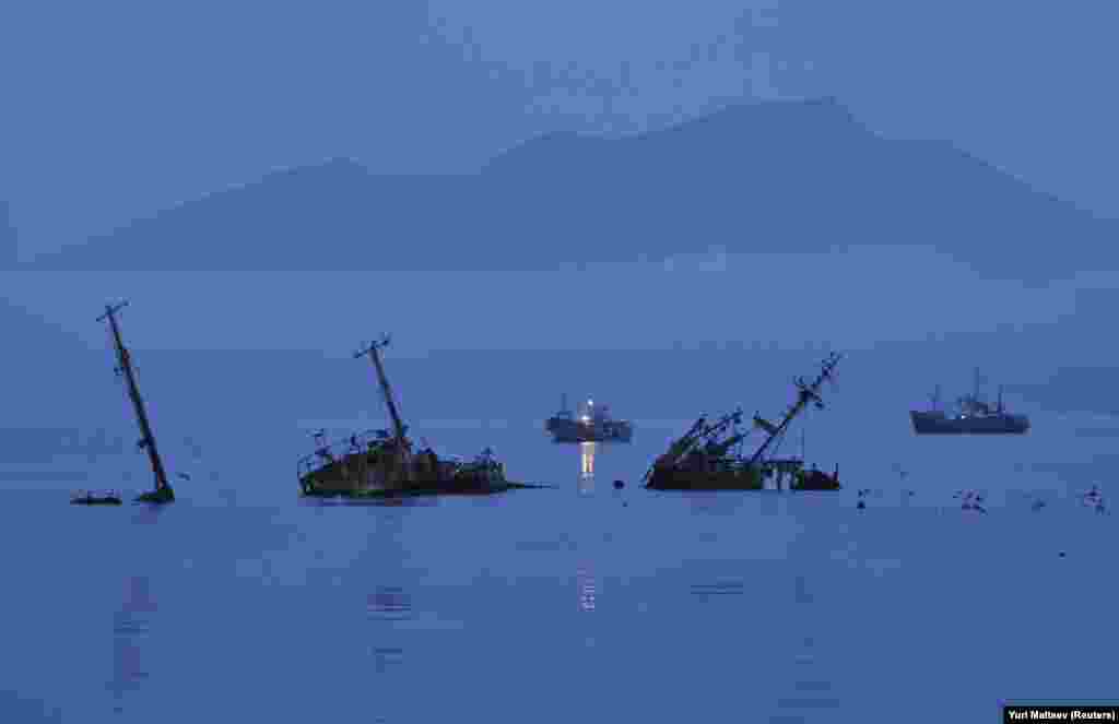 Сумерки в порту Кунашира. Рыболовство – основной источник дохода местного населения, но инфраструктура разрушена и перспективы экономического развития выглядят очень печально. В 2005 году один из изгнанных с острова японцев побывал на острове и заметил, что его бывшая родина теперь – "потерянная земля".