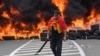 Muškarac pored zapaljenih guma na barikadi postavljenoj kako bi blokirala put na Cetinje tokom protesta protiv ustoličenja mitropolita Joanikija, 5. septembra 2021. godine