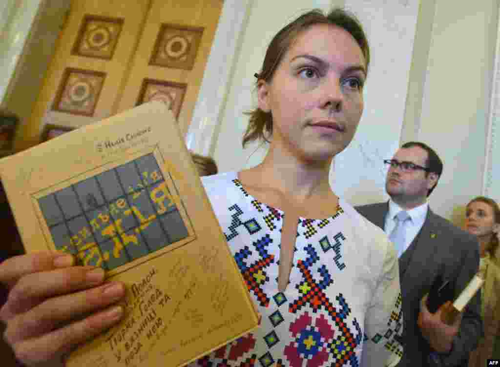 Вера Савченко держит книгу своей сестры "Сильное имя Надежда" на презентации в Верховной Раде