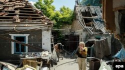 Місцева жінка біля зруйнованого будинку після обстрілу, Старомихайлівка, травень 2016 року 