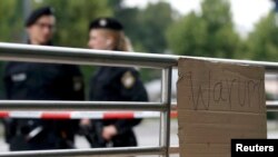 "Warum" (Zašto) piše na jednom kartonu na mestu ubistva civila ispred šoping centra "Olimpija", Minhen, 23. jul 2016.