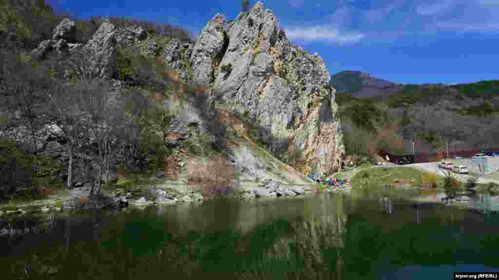 У скалы – небольшое озеро, которое питается подземными источниками. Справа – забор частного охраняемого землевладения