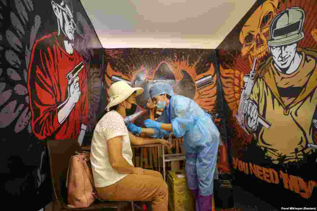 Женщина получает дозу вакцины от COVID-19 во временном отделении вакцинации, созданном в бывшей студии TikTok в торговом центре MEGA Park в Алматы, Казахстан