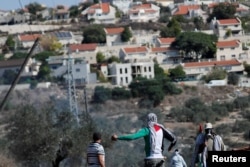 Palestinski demonstranti stoje ispred jevrejskog naselja za vrijeme protesta, u mjestu Kafr Qaddum na Zapadnoj obali okupiranoj Izraelom 13. novembra 2020.