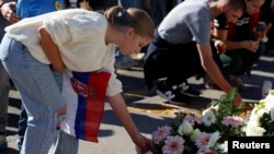 Хора полагат цветя пред жп гарата в Нови Сад, за да отбележат първата годишнина от фаталния срив на навеса на жп гарата през ноември 2024 г., при който загинаха 16 души. 1 ноември 2025 г.