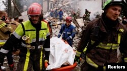 Спасатели выносят тело с места обрушения жилого дома в Киеве, Украина, 31 июля 2025 года