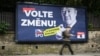 Un pieton trece pe lângă un panou electoral al unui partid de extremă dreapta care îi îndeamnă pe cehi să „voteze pentru schimbare”. 