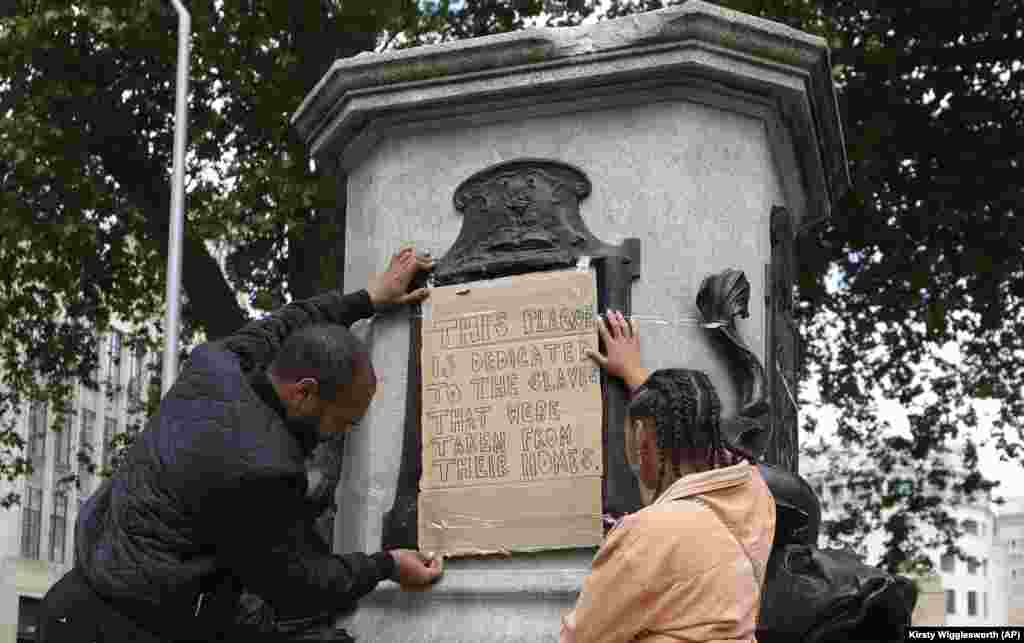 На постаменте, оставшемся после сноса статуи Эдварда Колстона, активисты разместили табличку: "Это место предназначено для рабов, увезенных из своих домов". Бристоль, 8 июня 