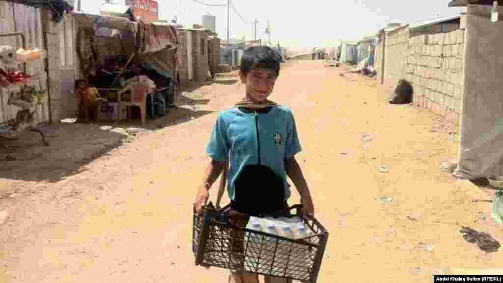 Part of an earlier wave of refugees, a child carries supplies at the Domeez refugee camp in Iraq's Duhok Province on July 4.