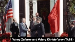 Sovjetski lider Mihail Gorbačov (drugi slijeva) rukuje se sa potpredsjednikom SAD Džordžom Bušom dok predsjednik Ronald Regan stoji iza njih prije razgovora u Njujorku u decembru 1988.