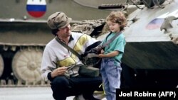 'Mi smo bili spremni. Mi smo mislili da ćemo ići izaći iz Jugoslavije ranije, ali smo čekali oružje, koliko ja znam.' (Slovenački vojnik i djevojčica pored tekova uzetih od JNA, 1991.)