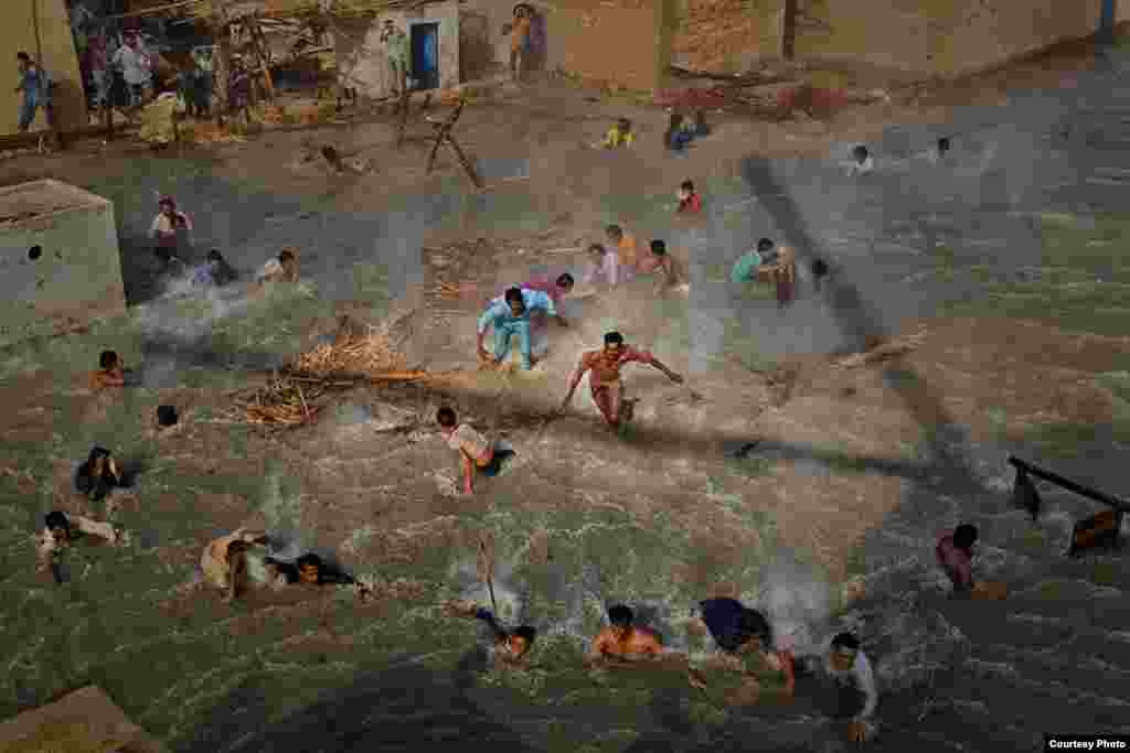 1-е место / Люди и события / серии Дэниел Берехулак, Австралия, Getty Images Наводнение в Пакистане, Август-сентябрь 2010: Жертвы наводнения пытаются добраться до продовольствия, борясь с воздушными потоками от винтов военного вертолета, доставившего гуманитарную помощь, Даду, Пакистан, 13 сентября 2010.