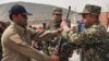 A Blue Hackle officer (left) hands over a gun to a soldier from the Afghan Public Protection Forces during a ceremony on the outskirts of Kabul in March.