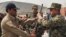 A Blue Hackle officer (left) hands over a gun to a soldier from the Afghan Public Protection Forces during a ceremony on the outskirts of Kabul in March.