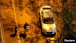 Žena nosi ćebe i jastuk dok trči u sklonište s detetom koje drži igračku tokom ruskog raketnog udara u Kijevu rano 17. novembra 2024.