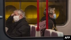 Ljudi sa zaštitnim maskama u metrou u Pragu