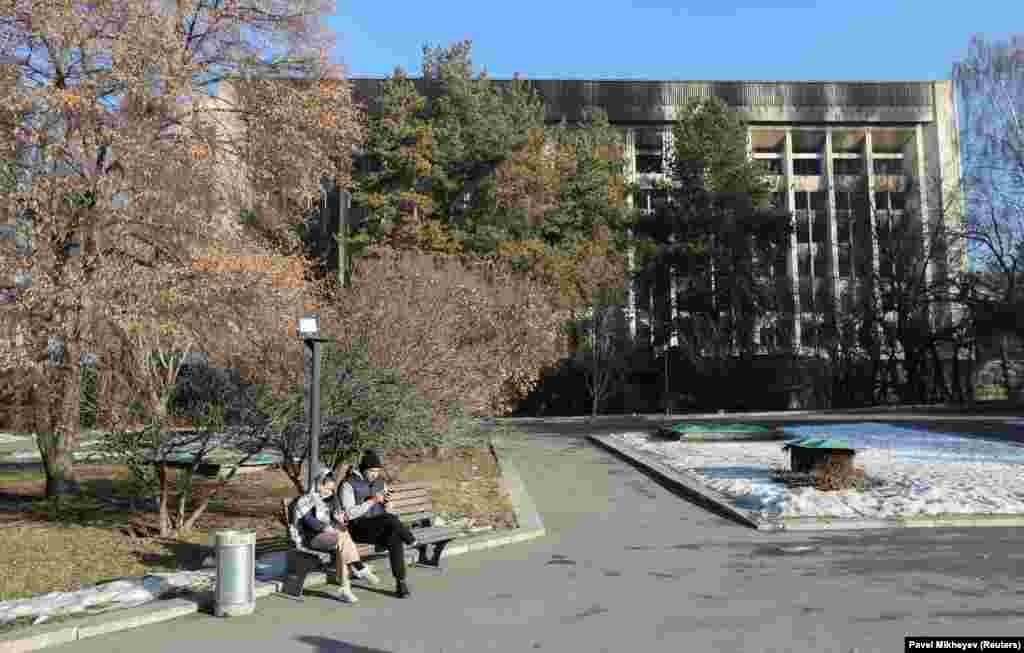 Ljudi na telefonima ispred izgorjele gradske vijećnice u Almatiju 12. januara.