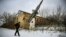 Мужчина проходит мимо разрушенного здания бывшей военной базы в селе Веселое, пригород Донецка