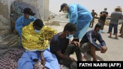 Мигранты, спасенные Национальной гвардией Туниса во время попытки пересечь Средиземное море на лодке. Порт Эль-Кетеф недалеко от границы с Ливией. 27 июня 2021 года