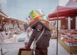 Робітник несе коробки на найхолоднішому ринку у світі, де просто неба продається заморожене м’ясо та риба