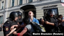 Поліція затримує протестувальницю під час акції опозиції в Москві 27 липня 2019 року