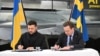 Prim-ministrul suedez Ulf Kristersson (R) și președintele ucrainean Volodimir Zelenski semnează o scrisoare de intenție pentru dezvoltarea capabilităților aeriene la Linköping, Suedia, pe 22 octombrie 2025.
