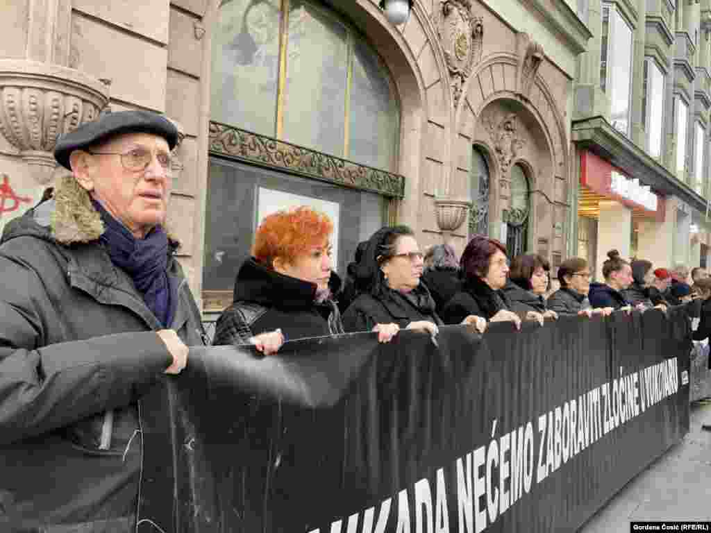 Tridesetak aktivista u crnini je ćuteći držalo je transparente.&nbsp;