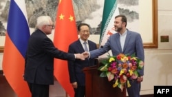 რუსეთის საგარეო საქმეთა მინისტრის მოადგილე სერგეი რიაბკოვი (მარცხნივ), ჩინეთის საგარეო საქმეთა მინისტრის აღმასრულებელი მოადგილე მა ჟაოშუ (ცენტრში) და ირანის საგარეო საქმეთა მინისტრის მოადგილე ქაზემ ღარიბაბადი პრესკონფერენციას მართავენ პეკინში, 14 მარტს.