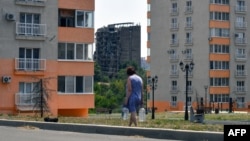 Женщина с бутылками воды в оккупированном Мариуполе.