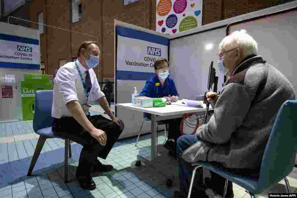 Simon Stevens (lijevo), izvršni direktor NHS-a, razgovara s pacijentom koji pohađa centar za vakcinaciju kako bi primio dozu vakcine Pfizer-BioNTech COVID-19 u bolnici u Londonu 8. decembra 2020. godine.