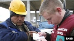 Росія -- Працівник Федеральної міграційної служби перевіряє документи у заробітчанина-будівельника.<br /> Ростов-на-Дону, 20 листопада 2008 р.