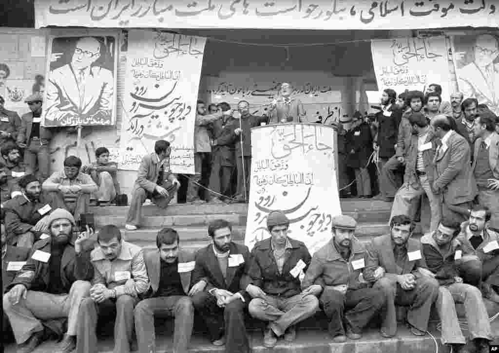 Uz veliko obezbjeđenje Mehdi Bazargan drži govor na teheranskom univerzitetu, 9. februara, 1979. Bazargana je ajatolah Homeini izabrao da preuzme iransku vladu. Bazargan je proglasio da će uvesti Alaha u sve faze života u Iranu, preobraziti ekonomiju i održati slobodne izbore prije povlačenja s položaja kako bi ustupio mjesti islamskom režimu.