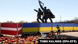 Памятник советским солдатам в Риге, окруженный забором в цветах латвийского и украинского флагов, в мае 2022 года, за три месяца до того, как он был снесен