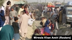 People wait outside the airport in Kabul on August 19.