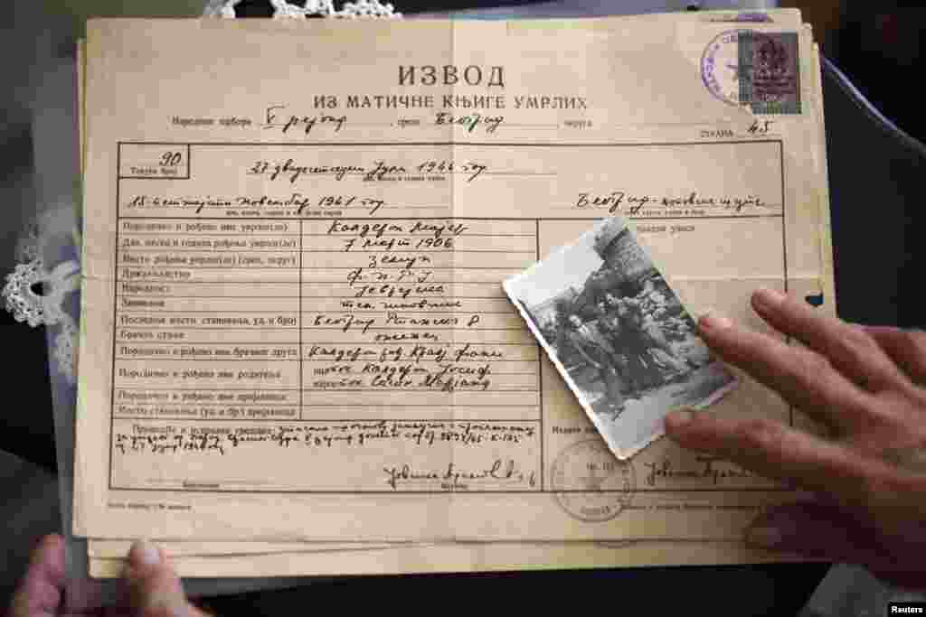 Marijana Sibinović pokazuje fotografiju oca i braće, koji su stradali u ovom nacističkom kampu za vrijeme Drugog svjetskog rata, Beograd, 29. juli 2013. Foto: REUTERS / Marko Đurica