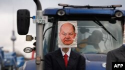 Protestat e bujqve në Gjermani. Njëri është parë me fotografinë e kancelarit gjerman, Olaf Scholz. Janar, 2024.