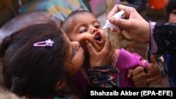 A health worker administers polio vaccine to children during a polio vaccination door-to-door campaign in Karachi on June 7.