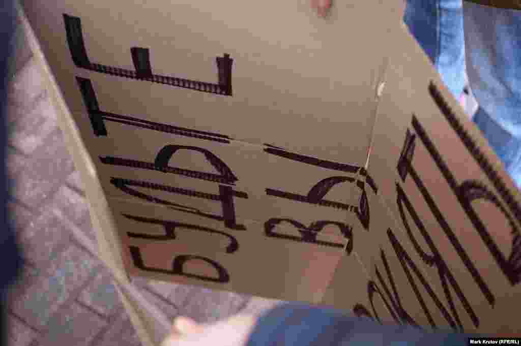 И его самодельный плакат с надписью "Будьте вы прокляты"