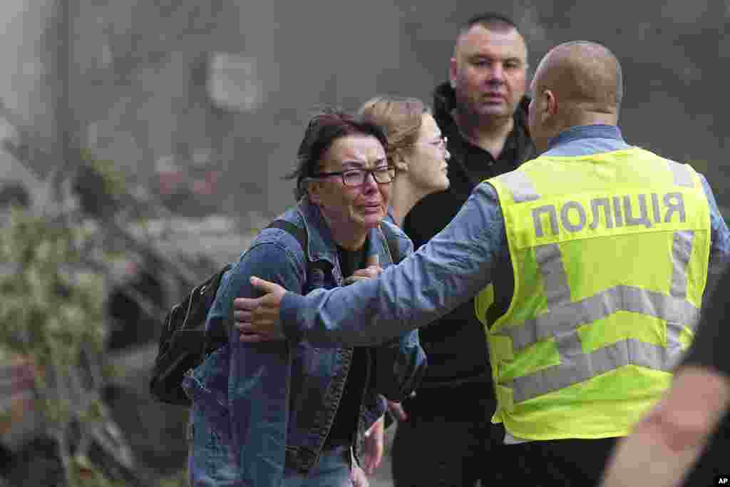 Ukrajinke plaču ispred uništene stambene zgrade nakon ruskog raketnog napada na Kijev.
