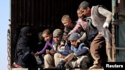 Borac Sirijskih demokratskih snaga daje hljeb djeci u blizini sela Baguz, februar 2019.