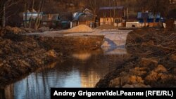 Вид с берега Казанки на свежевыкопанный канал и бетонный причал, весна 2021 года. Где-то выше, за садовыми домиками, теперь должен появиться коттеджный посёлок.