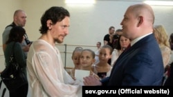 სერგეი პოპულინი, მას მხარზე აქვს იგორ ზელენსკის პორტრეტი.