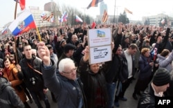 პრორუს აქტივისტს რუსეთის დროშა უჭირავს. აქცია დონეცკში, 15 მარტი, 2014 წელი.