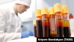 ექიმი იწერს აივ ტესტის მონაწილეთა სისხლის ანალიზის შედეგებს.