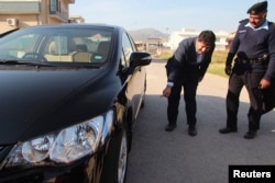 Geo journalist Hamid Mir points to where a bomb was found underneath his car in Islamabad in November 2012.