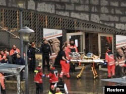 Spasilačke ekipe pomažu povređenima u napadu, 13. decembar 2011.