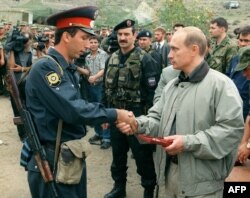 Tada premijer Rusije Vladimir Putin, uručuje nagradu nepoznatom dagestanskom milicajcu u ruskoj bazi u planinama Botlih u Dagestanu 27. avgusta 1999.