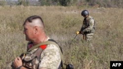 Українськи сапери під час розмінування поля неполік селища Луганське, вересень 2015 року