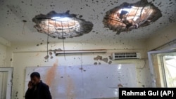 A man talks on his phone inside a damaged room at Kabul University following the deadly attack on November 3.