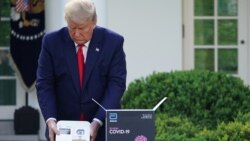 Američki predsednik Donald Tramp sa testom za prepoznavanje COVID-19 u pet minuta, tokom pres konferencije ispred Bele kuće, 30. marta 2020.